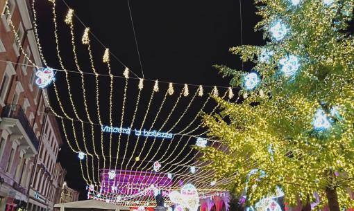 Luci natalizie e folla in una piazza decorata.