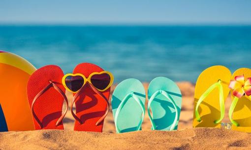 Spiaggia estiva con infradito, pallone e occhiali da sub.