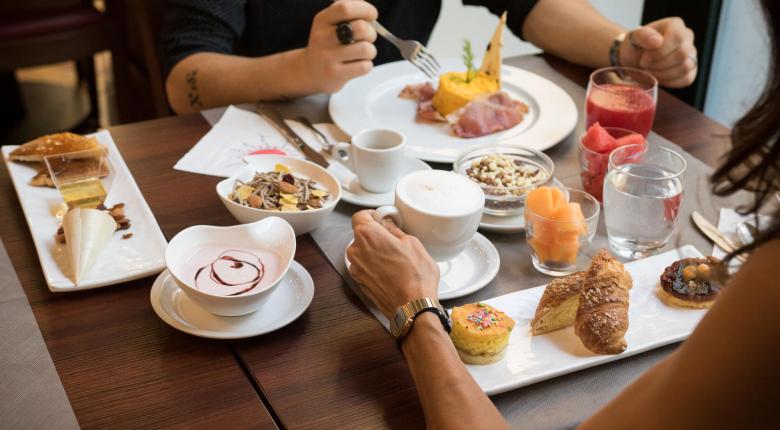 Breakfast with pastries, fruit, cereals, and coffee.